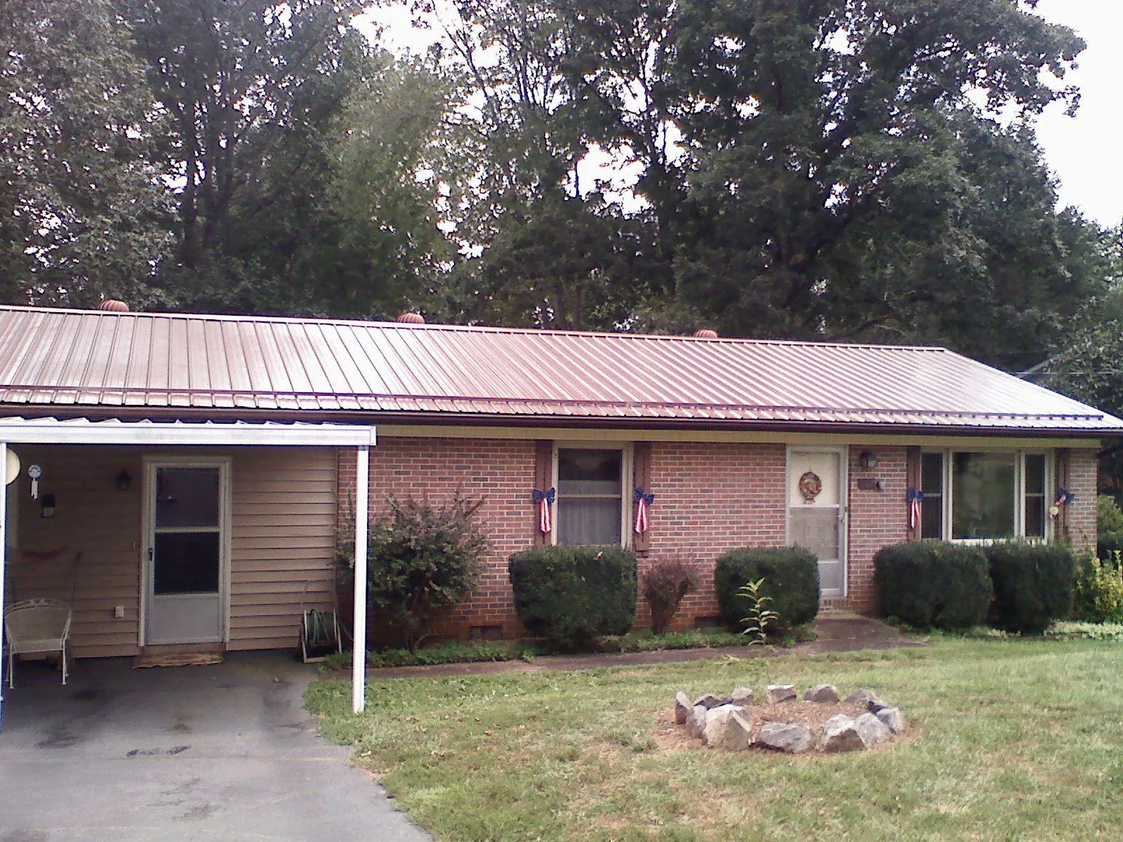 Bronze metal roof and carport on a brick ranch home — Roof Repair work by our crew in Pembroke